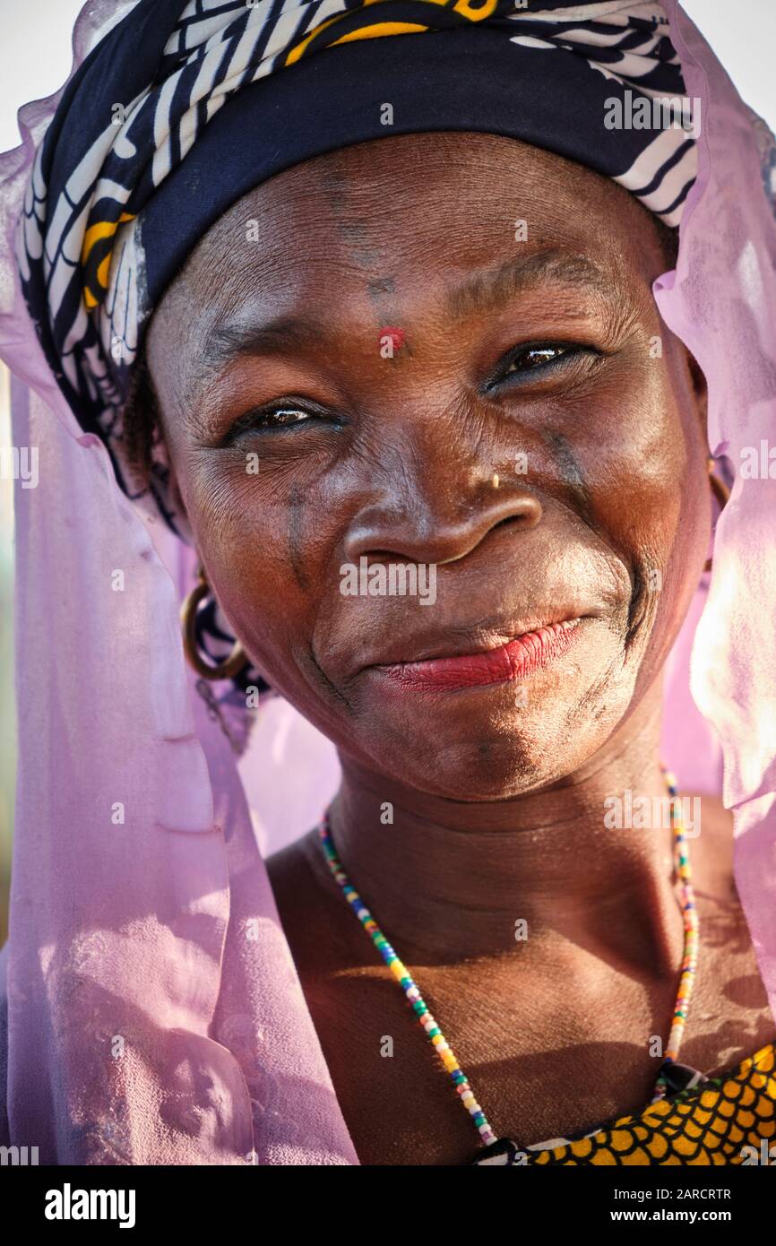 Portrait d'une femme avec tatouages faciaux vendant de la nourriture dans un marché de rue. Banque D'Images