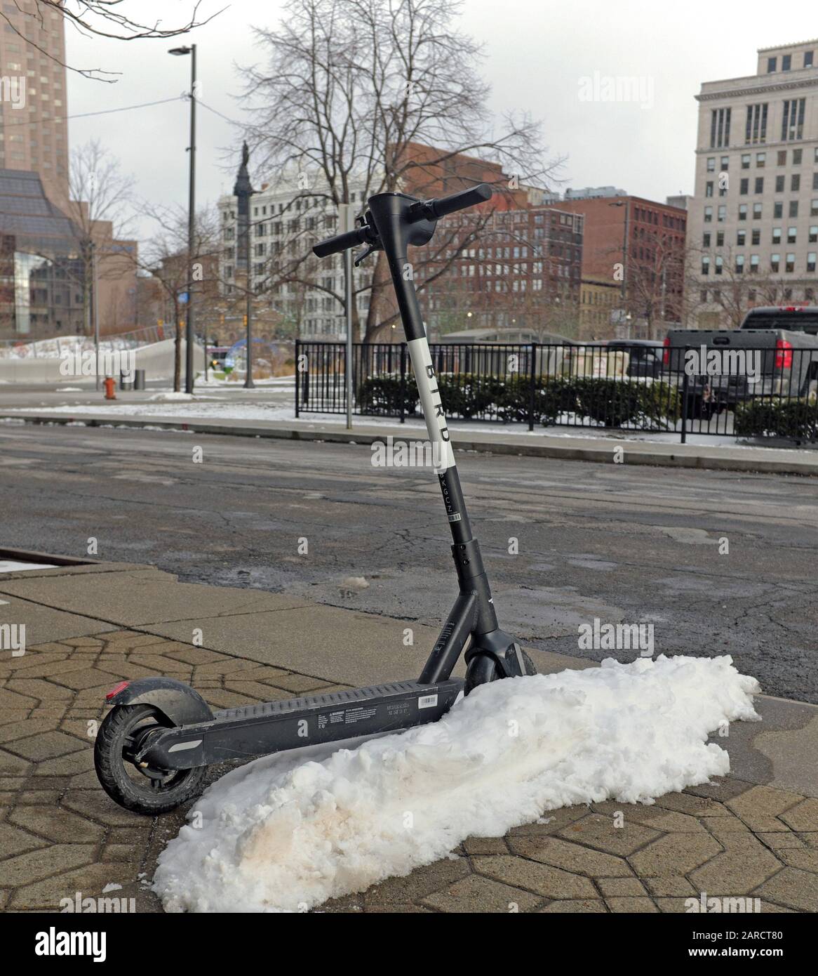 Un scooter électrique Bird sans quai est infus dans une pile de neige à Cleveland, Ohio, États-Unis. Banque D'Images