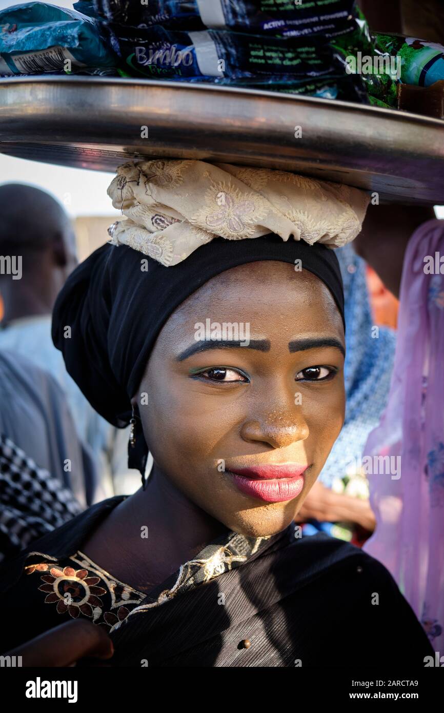 Portrait d'une jeune femme avec une forme jaune vendre de la nourriture dans un marché de rue. Banque D'Images