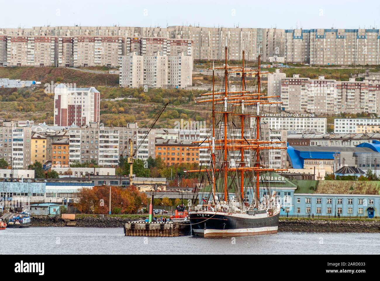 Grand navire Sedov dans le port de Mourmansk avec la ville en arrière-plan, vu de la mer, Russie Banque D'Images