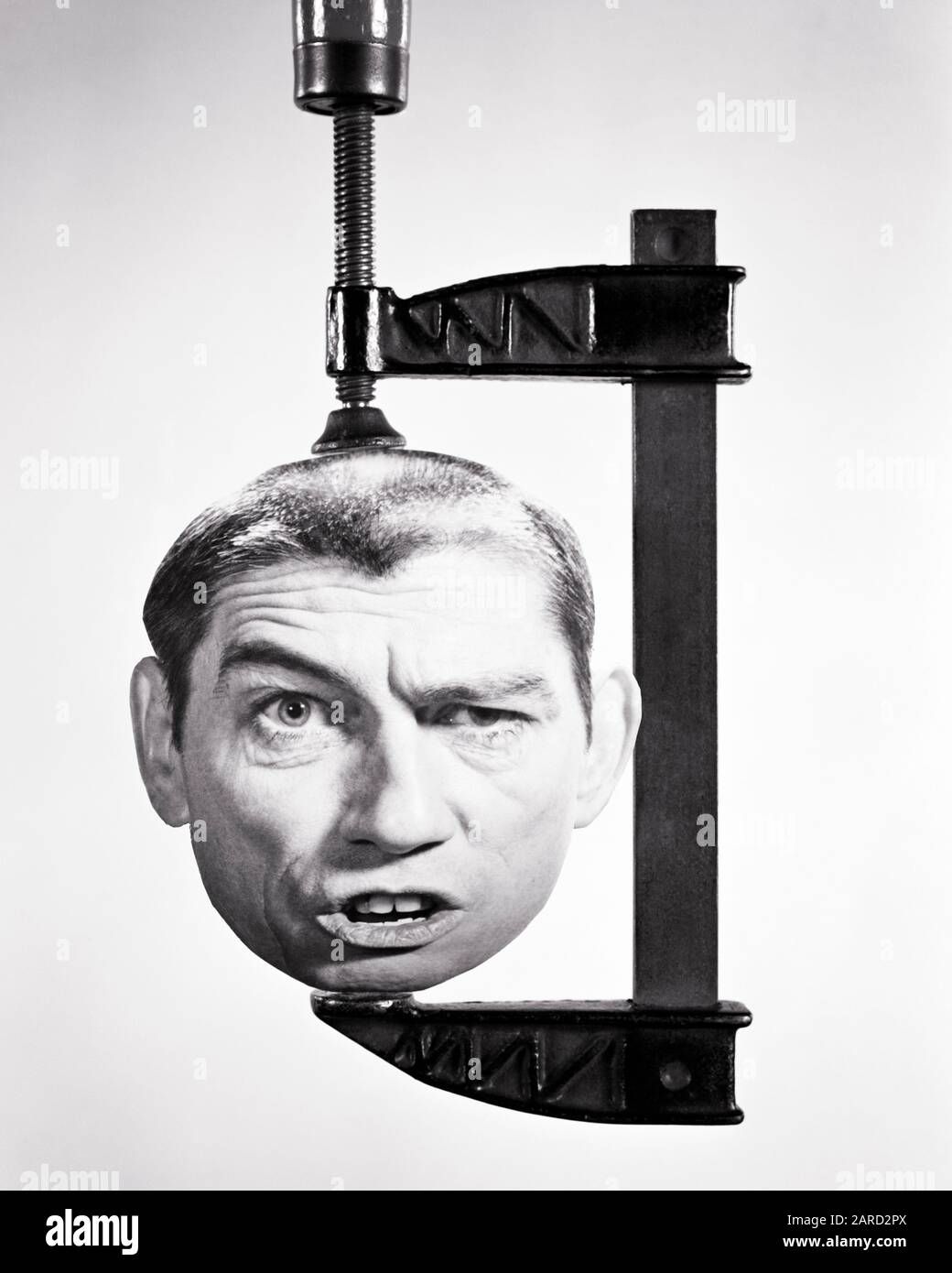 ANNÉES 1960 TÊTE DE L'HOMME AVEC UNE DRÔLE D'EXPRESSION FACIALE EN TRAIN D'ÊTRE ÉCRASÉ DANS UNE PINCE À BOIS - S18696 HAR001 HARS CONTACT YEUX BIZARRE TÊTE ET ÉPAULES COMPOSITE PUISSANT SQUAGONIE ZANY POLITIQUE NON CONVENTIONNELLE VICE-ÉVASION CONCEPTUELLE PRESSÉ COMPRESSION IDIOSYNCRATIQUE INTIMIDATION HARCÈLEMENT SYMBOLIQUE TRAVAIL DU BOIS AMCLAMP EXCENTRIQUE MILIEU ADULTE MOYENNE TAILLE NAG SQUEEZE ORIGINE ETHNIQUE CAUCASIENNE NOIRE ET BLANCHE IRRÉGULIÈRE HAR001 DÉMODÉE Banque D'Images