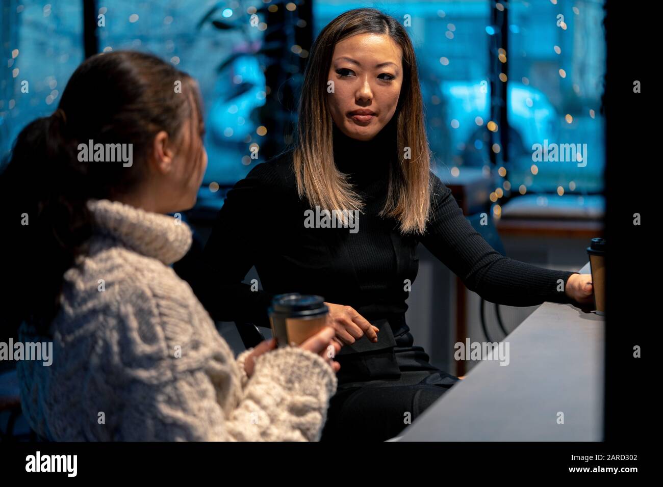 Caucasien Et Asiatique Jeunes Femmes Parler Dans Le Café Et Le Café. Concept D'Amitié Multiethnique Et Internationale. Banque D'Images