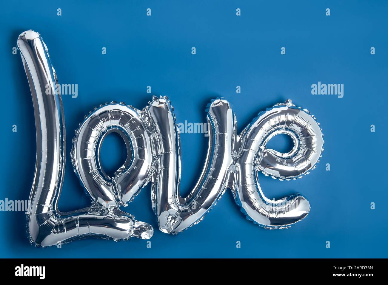 Ballons en feuille d'argent sous la forme d'un mot Amour. Bonne Saint Valentin. Concept de festival d'amour. Les ballons rendent les gens heureux. Bleu classique tendance couleur b Banque D'Images