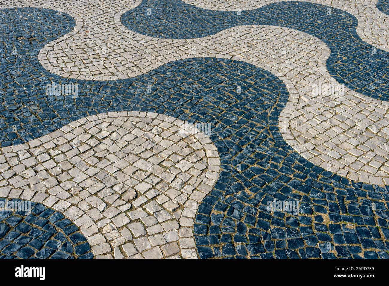 Motif pavés traditionnels au Portugal, pavés noir et blanc, à motif vagues. Banque D'Images