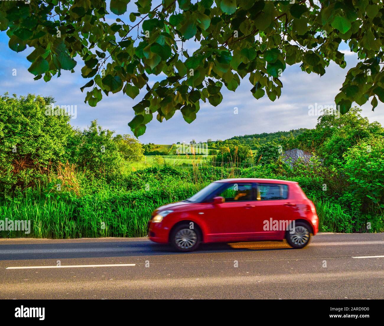 voiture rouge sur une route rurale Banque D'Images
