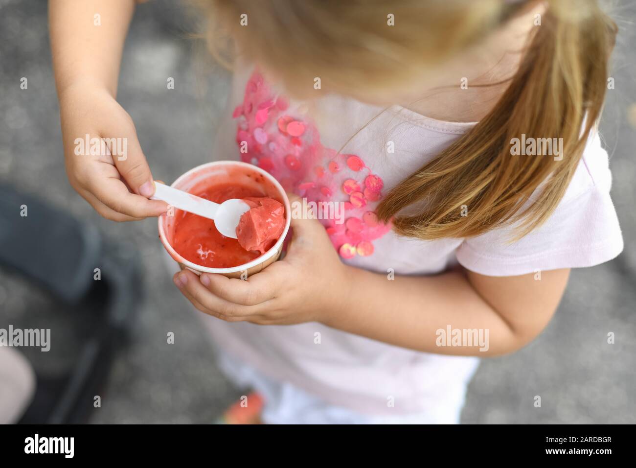 Fille mange de la glace rose. Vue de dessus Banque D'Images