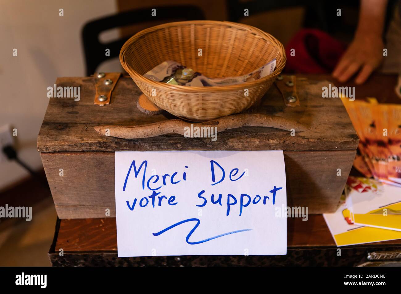 Vue en grand angle du panier en bois avec note de message en texte bleu et  monnaie papier dans le panier au-dessus de la table avec accent sur le  premier plan Photo