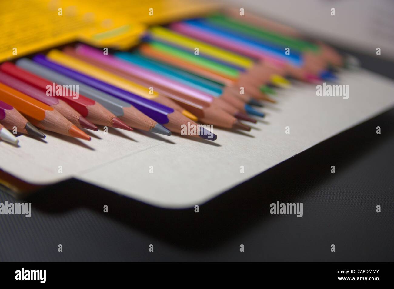 Vue en perspective d'une boîte de crayons de couleur qui sont désordonnés et hors du foyer créant un espace pour ajouter des textes ou des graphiques. Espace de copie Banque D'Images