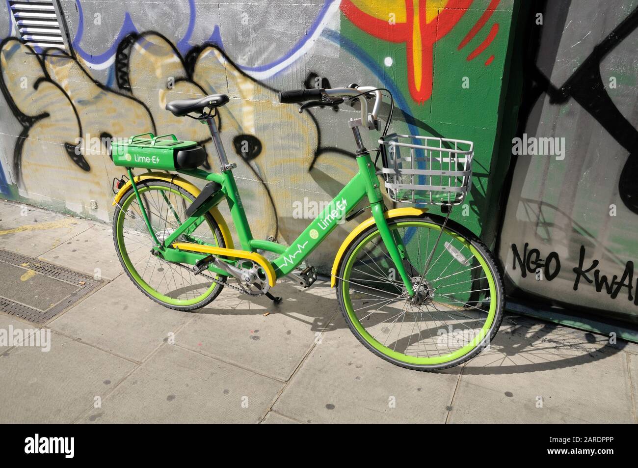 Vélo électrique Lime-E incliné contre un mur de graffitis, Londres, Angleterre, Royaume-Uni Banque D'Images