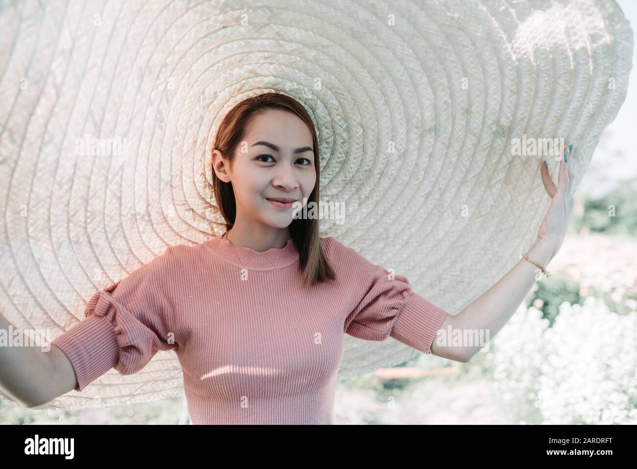 Belle femme d'Asie qu'elle aime avec le grand chapeau dans la fleur de jardin Banque D'Images