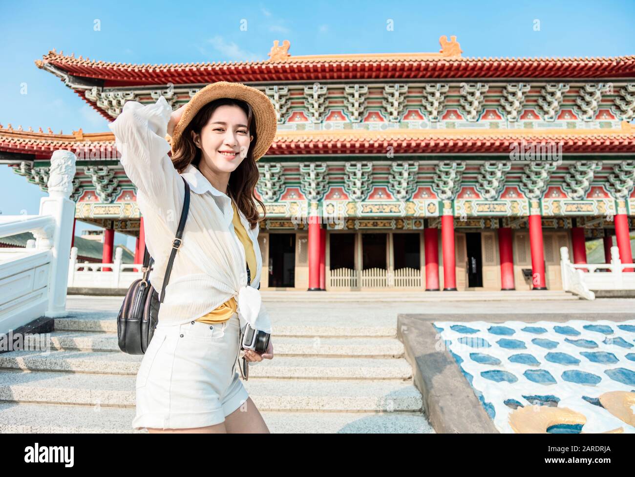 Happy Young Backpacker femme se tient devant le temple chinois traditionnel Banque D'Images