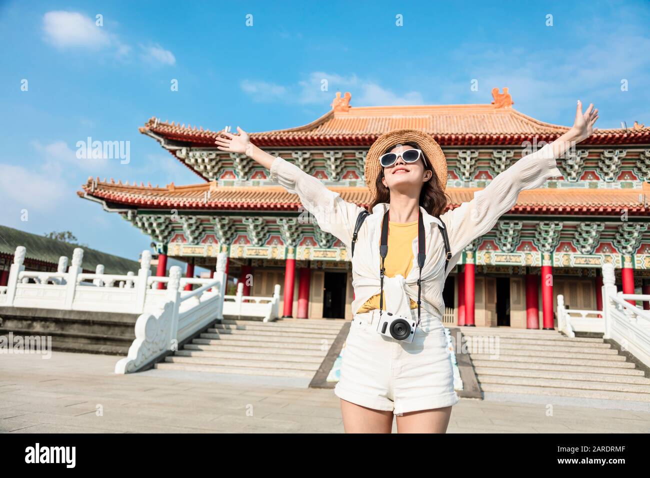 Happy Young Backpacker femme se tient devant le temple chinois traditionnel Banque D'Images