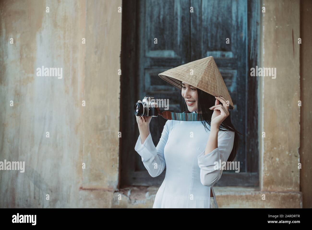 Fille profiter avec un film d'appareil photo vintage et porter Ao Dai vietnamienne traditionnelle robe Voyage dans la vieille ville Banque D'Images