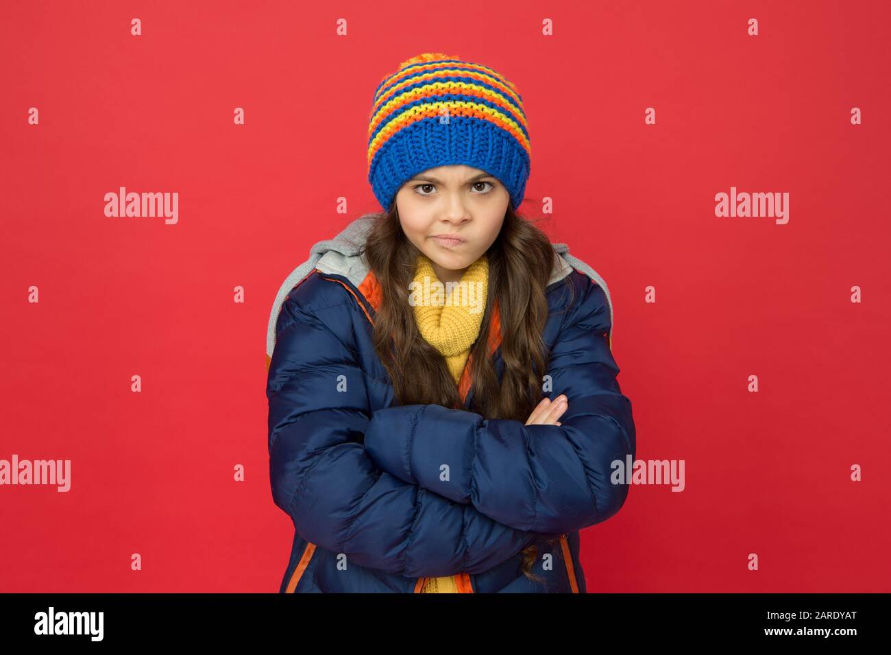 Je Ne Pense Pas Bebe Strict Et Grave Petite Fille Porter Hiver Vetements Rouge Fond Concept D Enfance Fille Emotionnelle Long Cheveux Tricote Chapeau Jeune Fille Style Decontracte Emotions Et Humeur Photo Stock