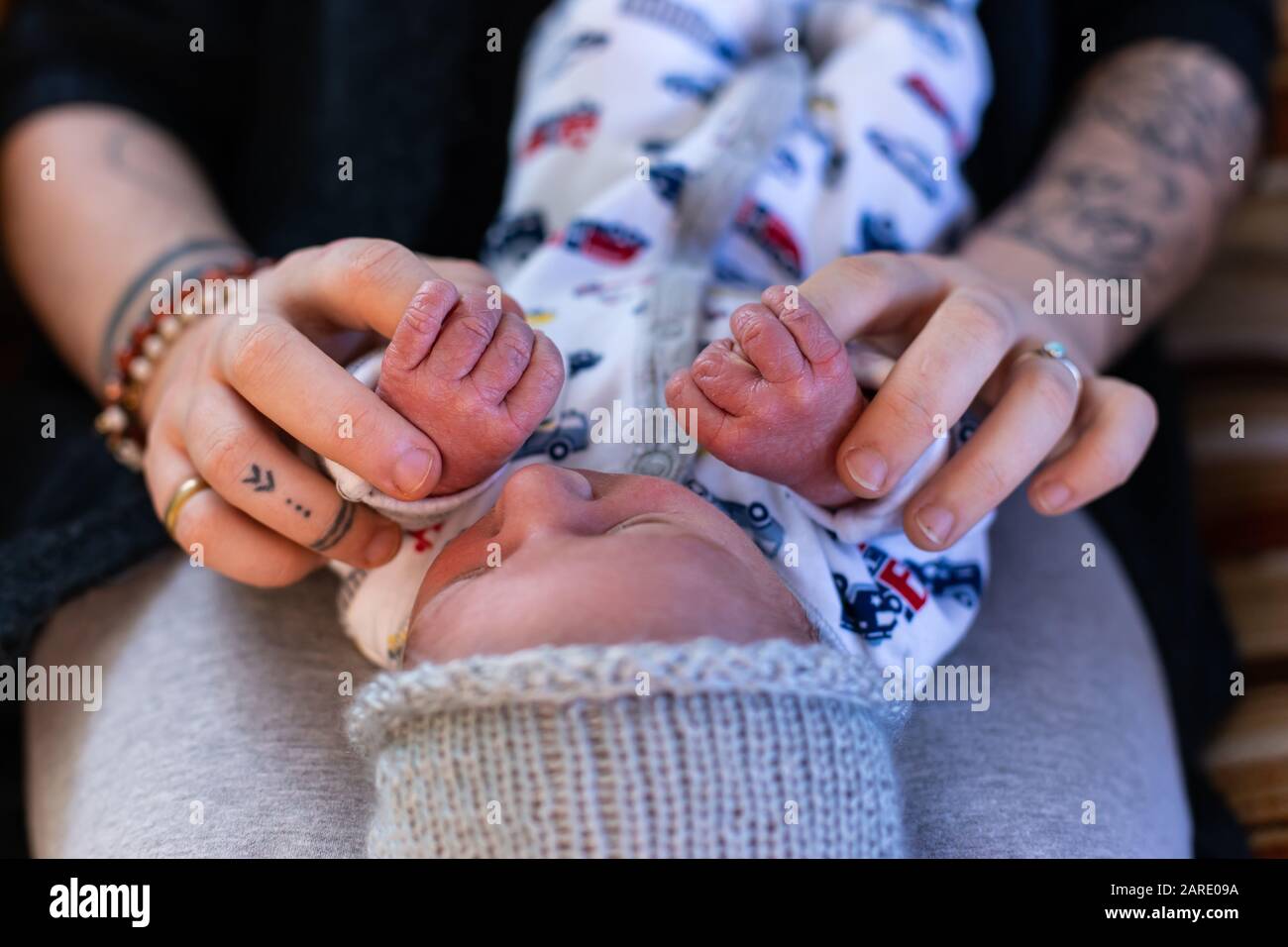 Une vue rapprochée et recadrée d'une nouvelle mère et d'un bébé garçon se liant à la maison, tenant les mains dans les jours après la naissance, beau moment de la parentalité. Copier l'espace sur les côtés Banque D'Images