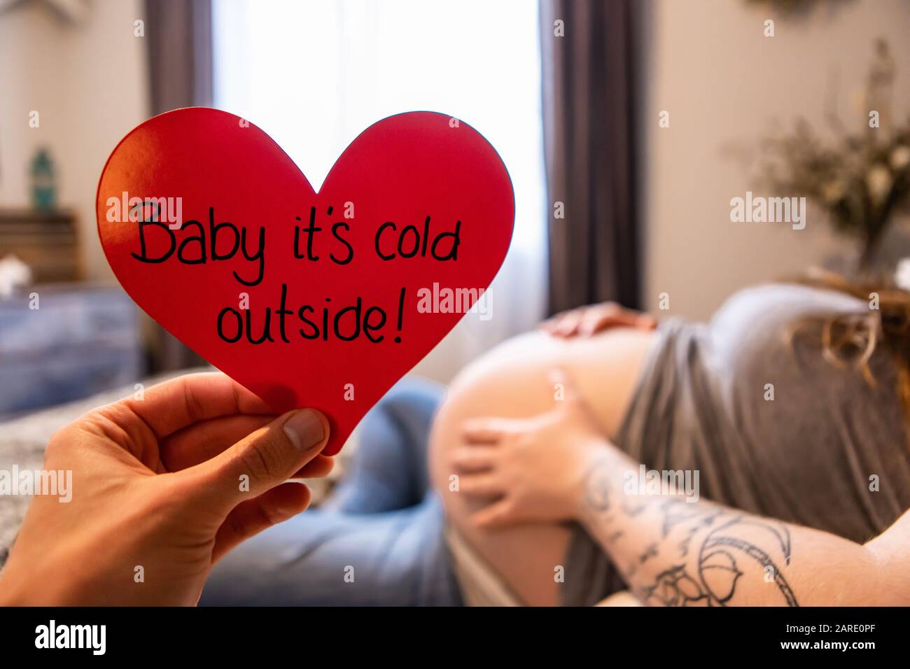 Une Mise Au Point Selective Premiere Personne Perspective D Une Main Tenant Un Cœur Rouge Avec Message Bebe Son Froid A L Exterieur Car La Femme Fortement Enceinte Repose Dans Le Lit Photo Stock