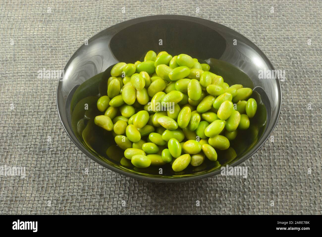 Ingrédient cru de légumes de soja à base d'édamame dans un bol noir sur toile de fond Banque D'Images