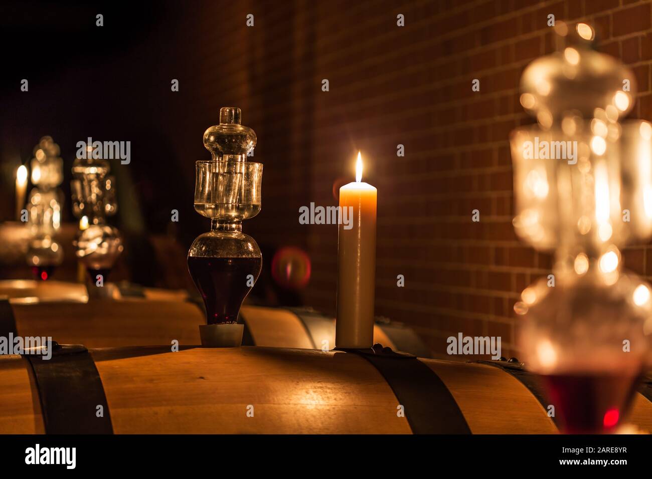 Mise au point sélective de fûts de vin avec une bougie allumée Banque D'Images