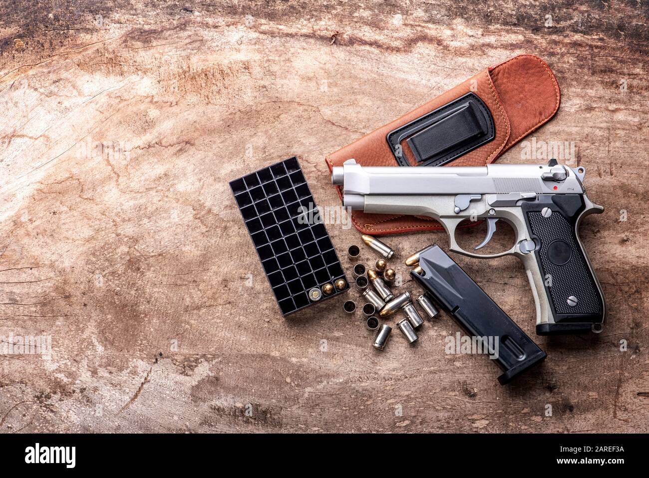 balles de pistolet de 9 mm et magazine parsemés sur le fond en bois vue de dessus - style vintage film grain filtre effet de styles Banque D'Images