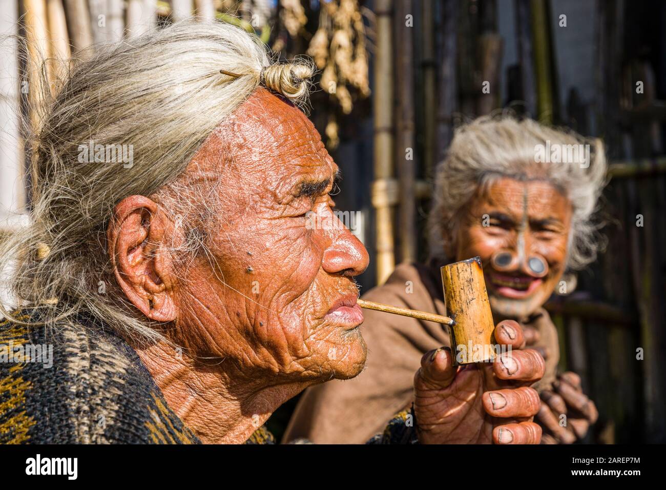 Portrait d'un vieil homme d'Apatani portant la coiffure traditionnelle avec le knop à son front, pipe fumeur Banque D'Images