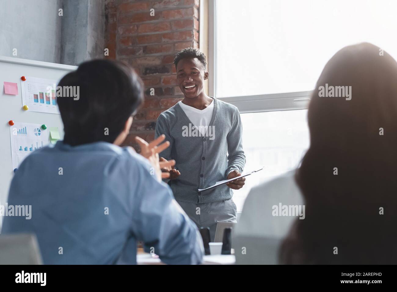 Employé noir gai parlant à ses collègues pendant la présentation Banque D'Images