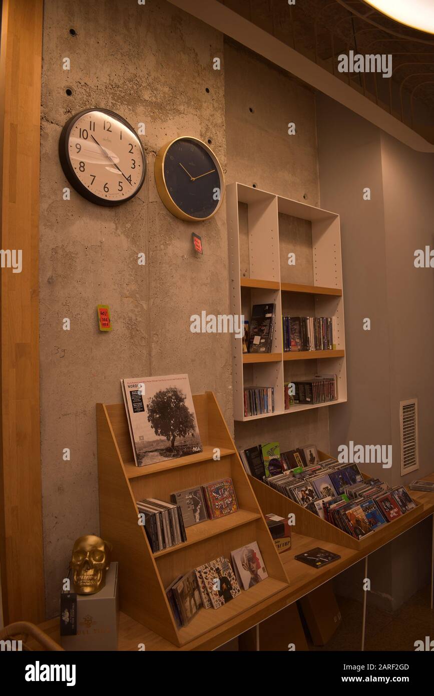 Un mur avec deux horloges et une étagère avec des livres Banque D'Images