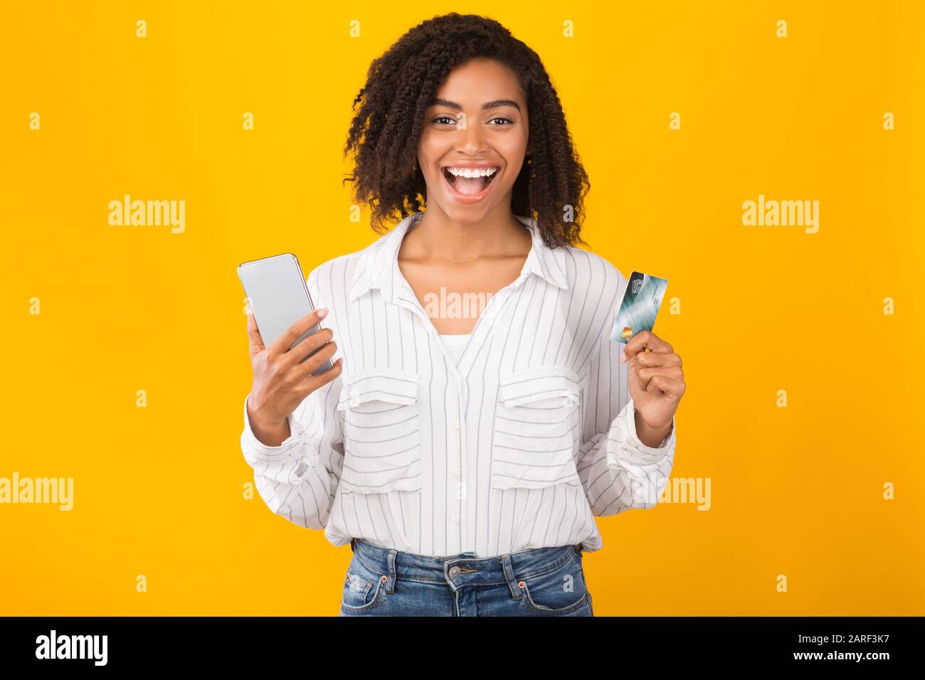 Femme noire avec carte de crédit et téléphone portable Banque D'Images