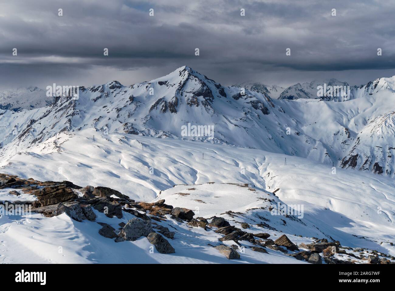 Vue du sommet de la masse dans la station française des Menuires à travers les alpes. Une banque de cloud se trouve au-dessus des pics éloignés. Banque D'Images