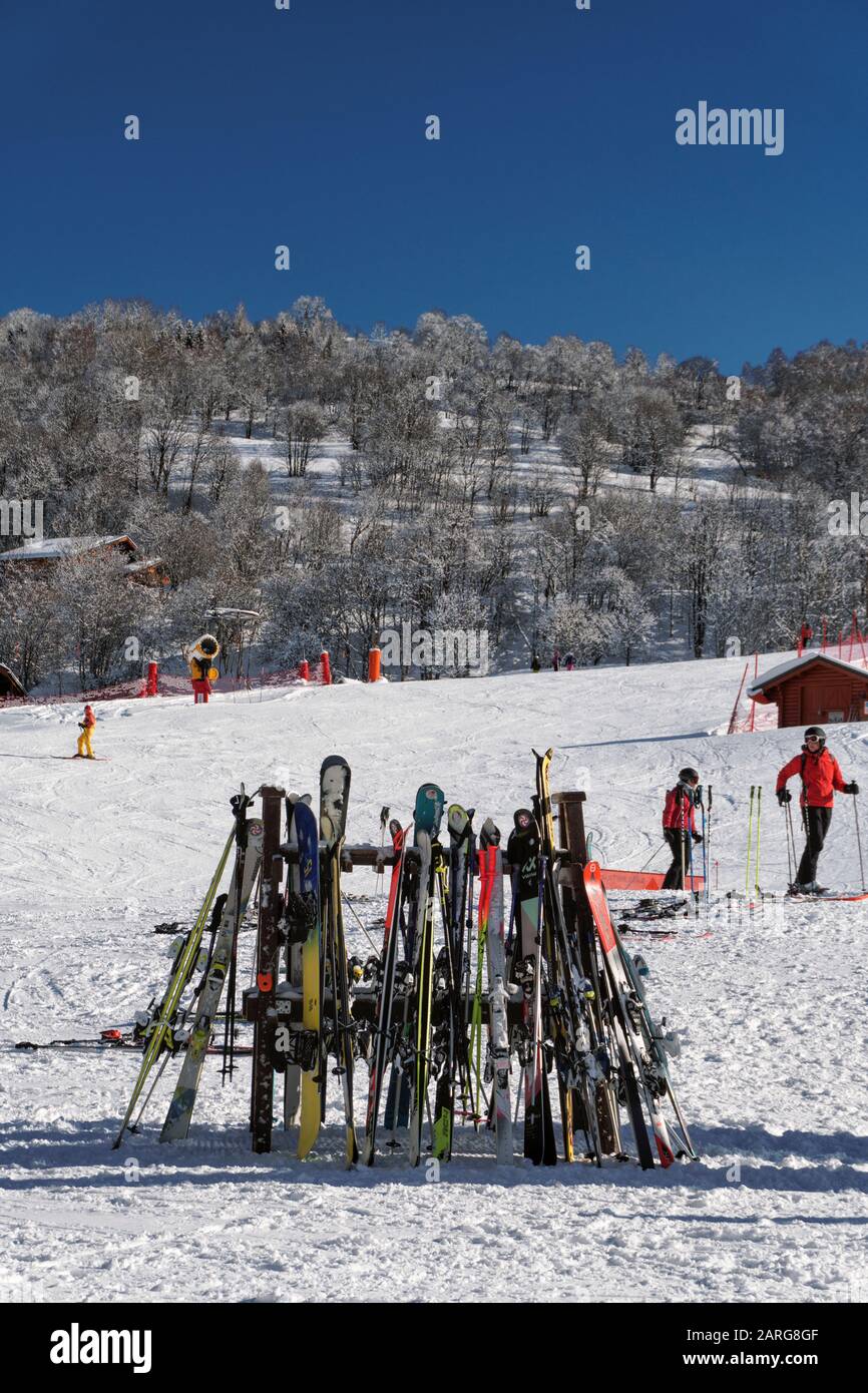 Les skis penchant sur un rack à l'extérieur d'un restaurant sous un ciel bleu clair dans la station de ski de St Martin de Belleville dans les alpes françaises Banque D'Images