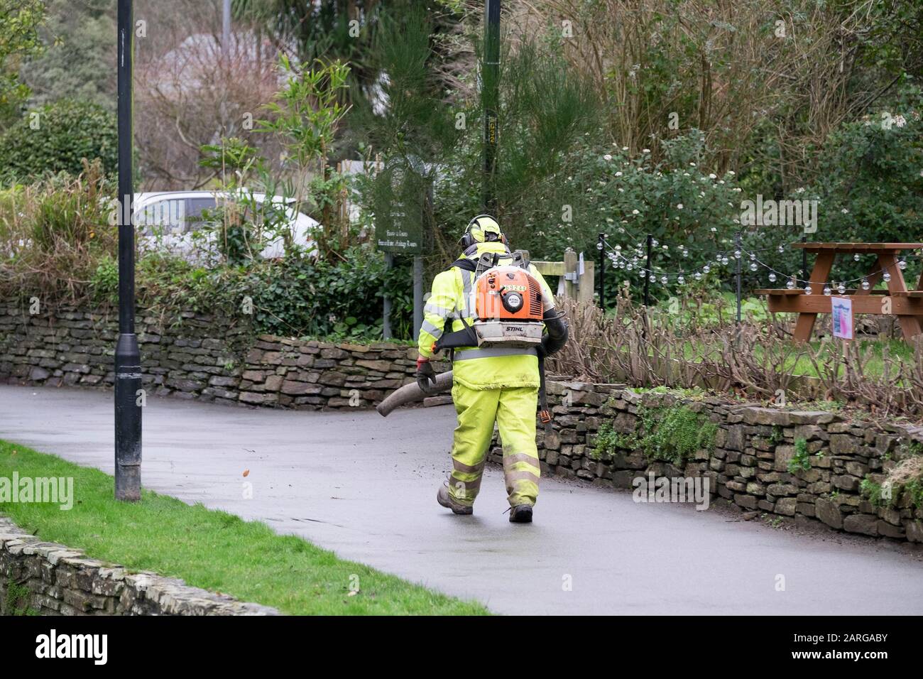 Un travailleur portant des vêtements haute visibilité et utilisant un souffleur de feuilles Stihl à Trenance Park à Newquay, en Cornwall. Banque D'Images
