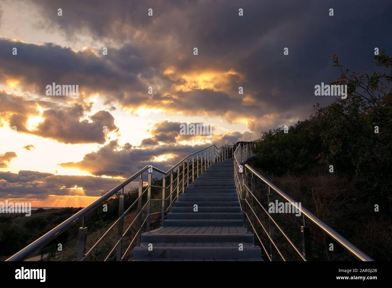 Escalier avec rambarde en métal menant au ciel d'orage Banque D'Images