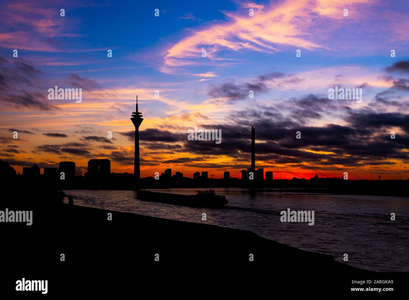 Silhouette noire de la tour de télévision de Düsseldorf et pont du Rhin au coucher du soleil avec de belles couleurs Banque D'Images