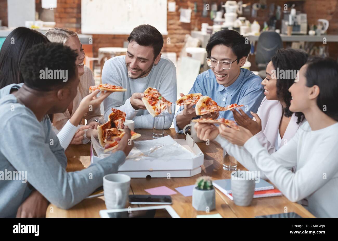 Une équipe d'affaires positive mangeant de la pizza au bureau Banque D'Images