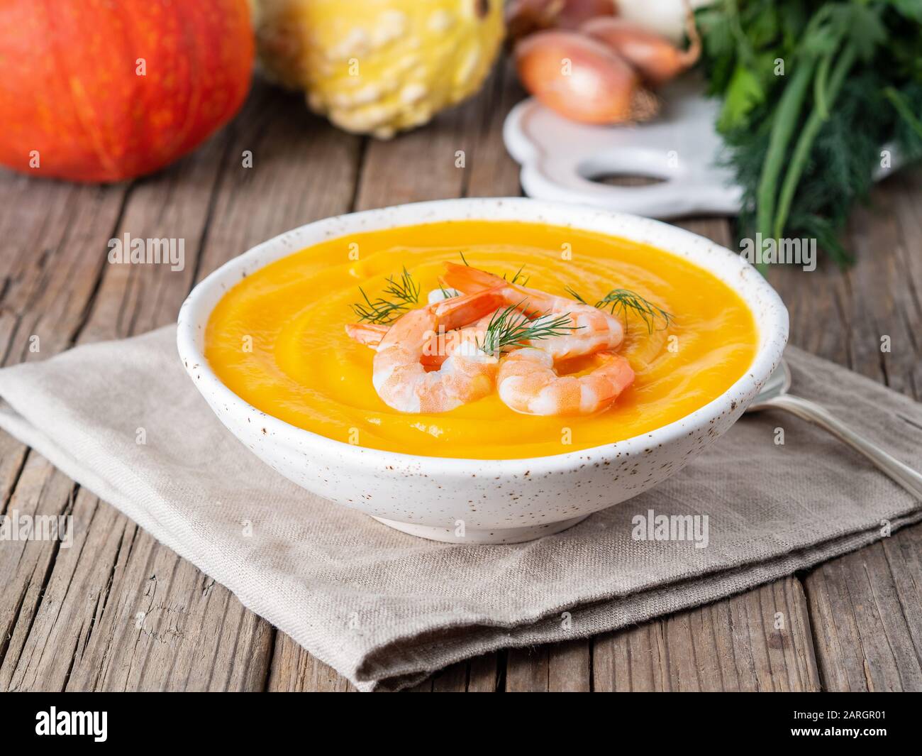 Délicieuse soupe à la crème de citrouille jaune avec crevettes sur une vieille table en bois rustique gris foncé, vue latérale Banque D'Images
