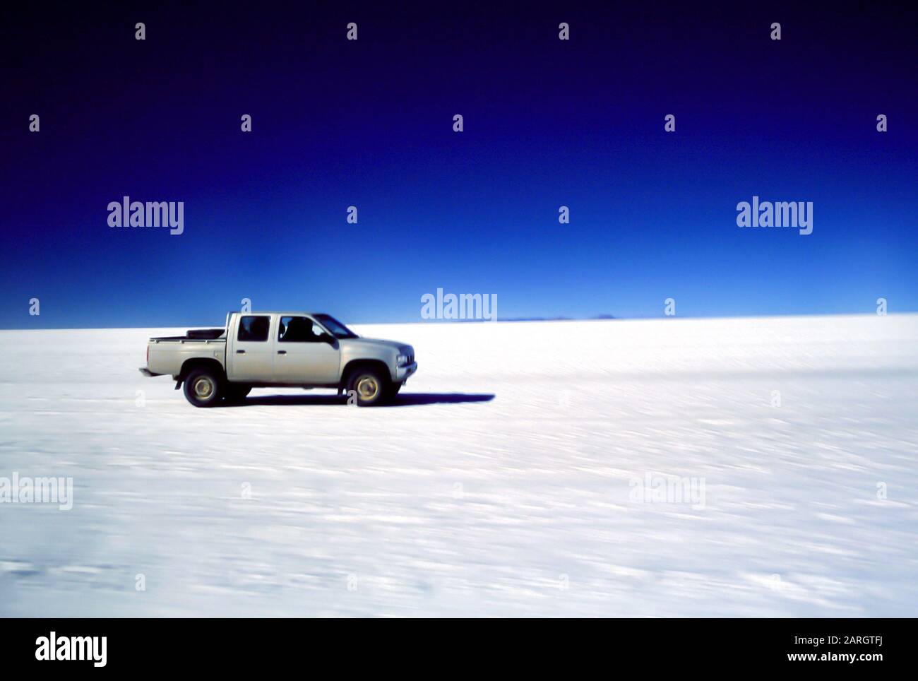 Salar de Uyuni, Bolivie, Amérique latine: Un pick-up de voiture court sur l'étendue de sel du Salar de Uyuni Banque D'Images