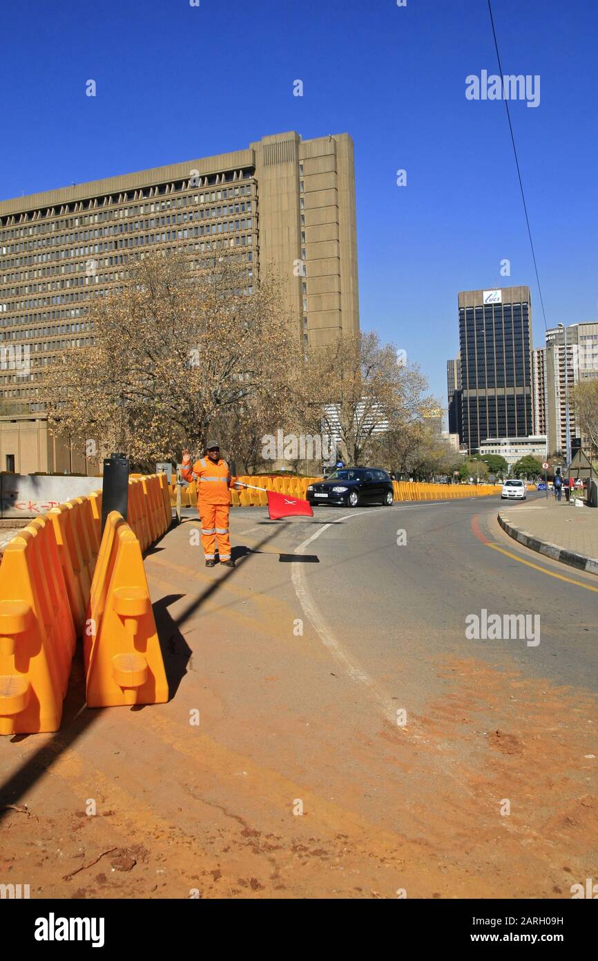 Travaux routiers et travailleurs de la route régulant la circulation avec des barrières de sécurité routière dans la rue, Braamfontein, Johannesburg, Gauteng, Afrique du Sud. Banque D'Images