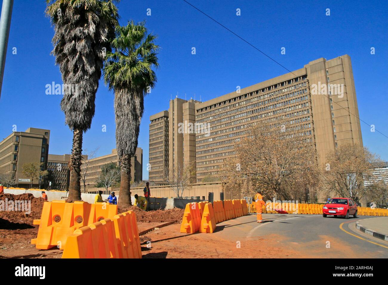 Travaux routiers et travailleurs de la route régulant la circulation avec des barrières de sécurité routière dans la rue, Braamfontein, Johannesburg, Gauteng, Afrique du Sud. Banque D'Images