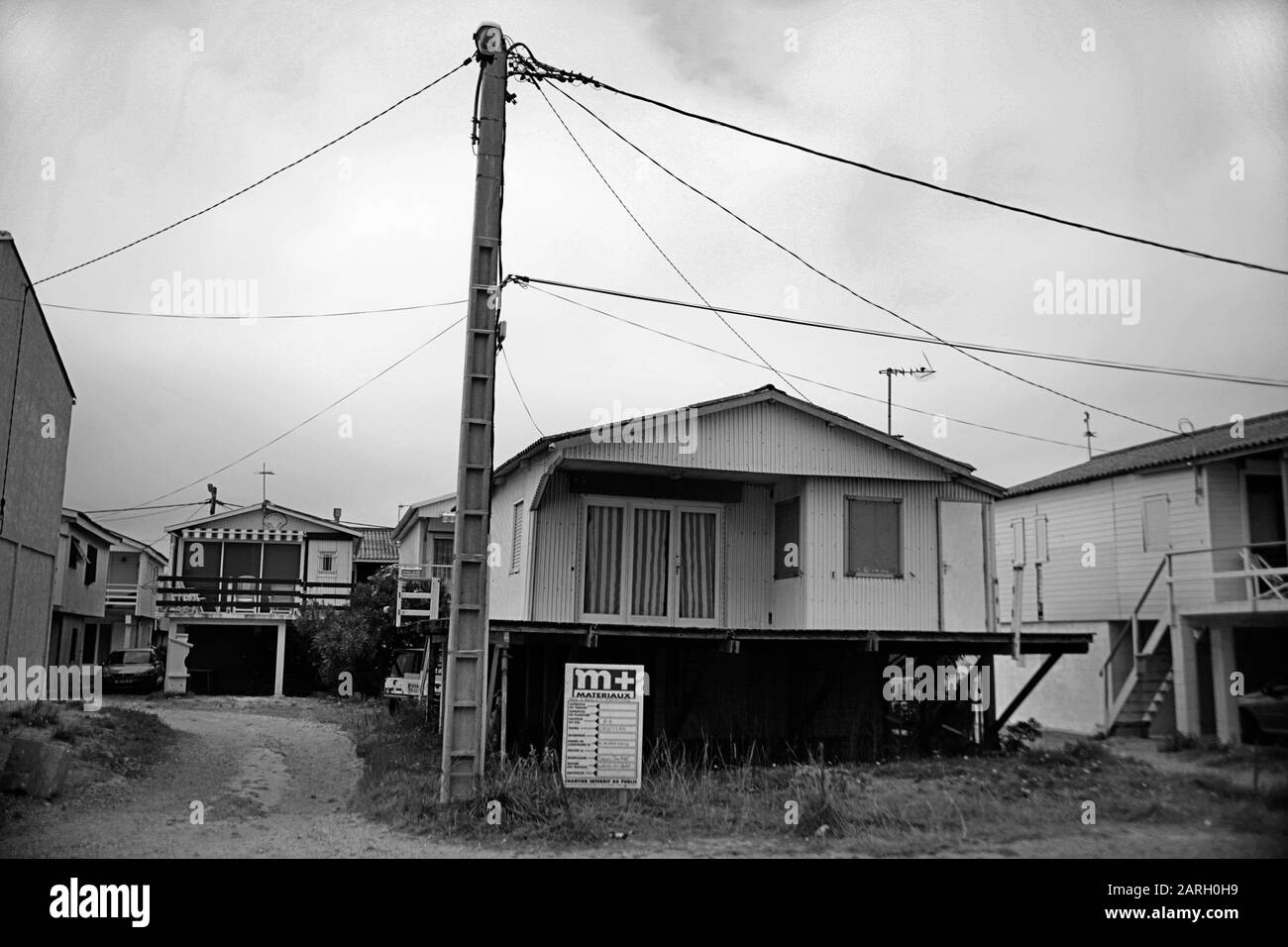 Chalets en bois sur pilotis, rue des Cormorans, Gruissan Plage, Aude, Occitanie, France: Un des endroits pour le film "Betty Blue" (37° 2 le matin), 1986, par Jean-Jacques Beineix. Image en noir et blanc Banque D'Images