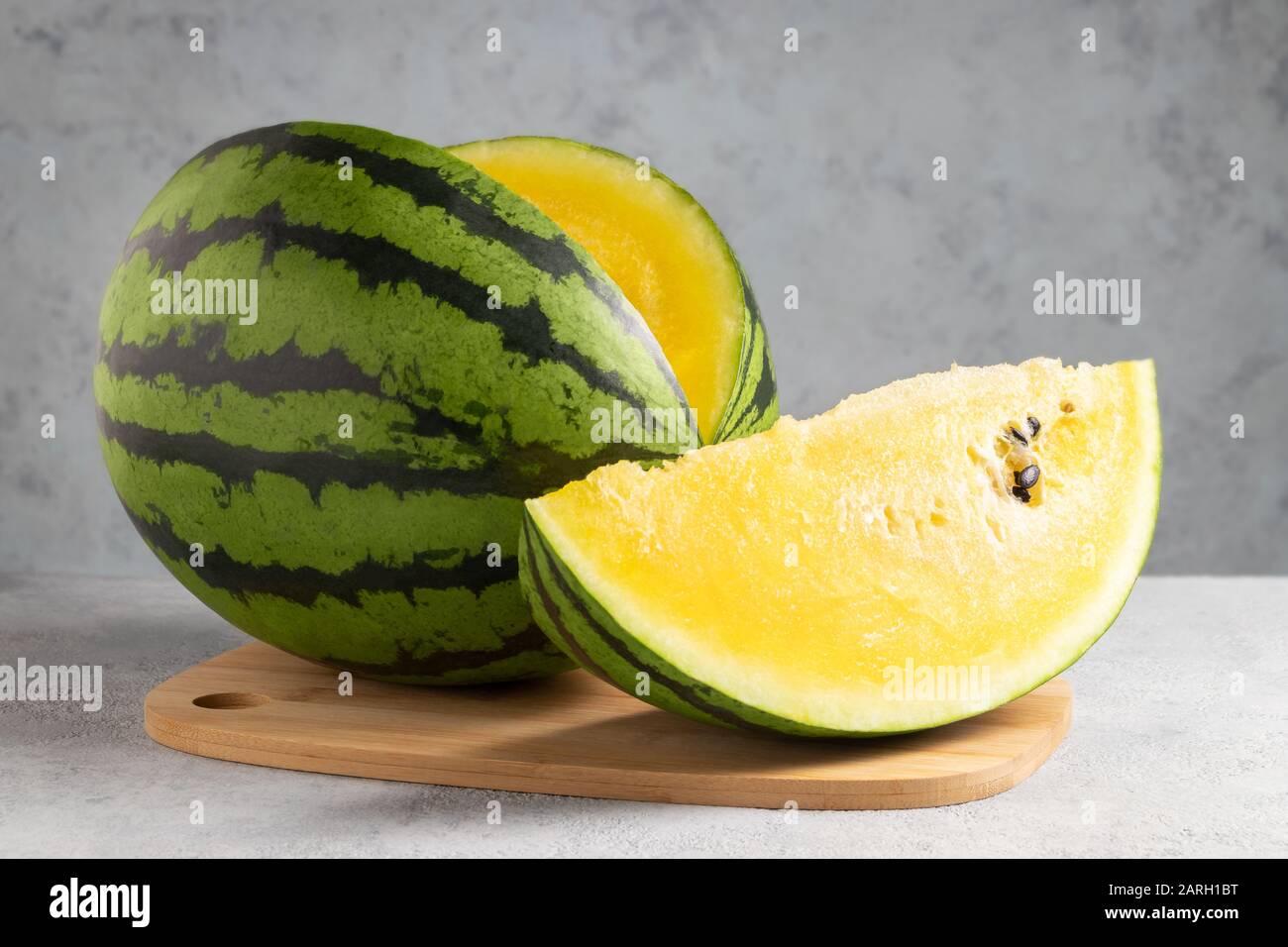 Pastèque jaune en tranches sur une planche à découper en bois sur une table. Banque D'Images