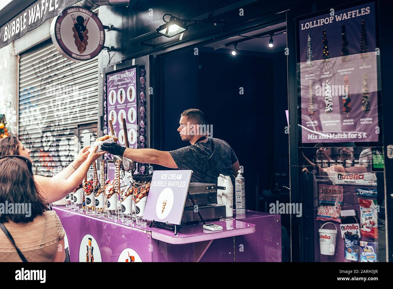 Londres/Royaume-Uni - 17 juillet 2019 : femme achetant des gaufres à bulles dans un stand de Camden High Street à Camden Town. Originaire de Hong Kong, ce que l'on appelle le waffl des œufs Banque D'Images