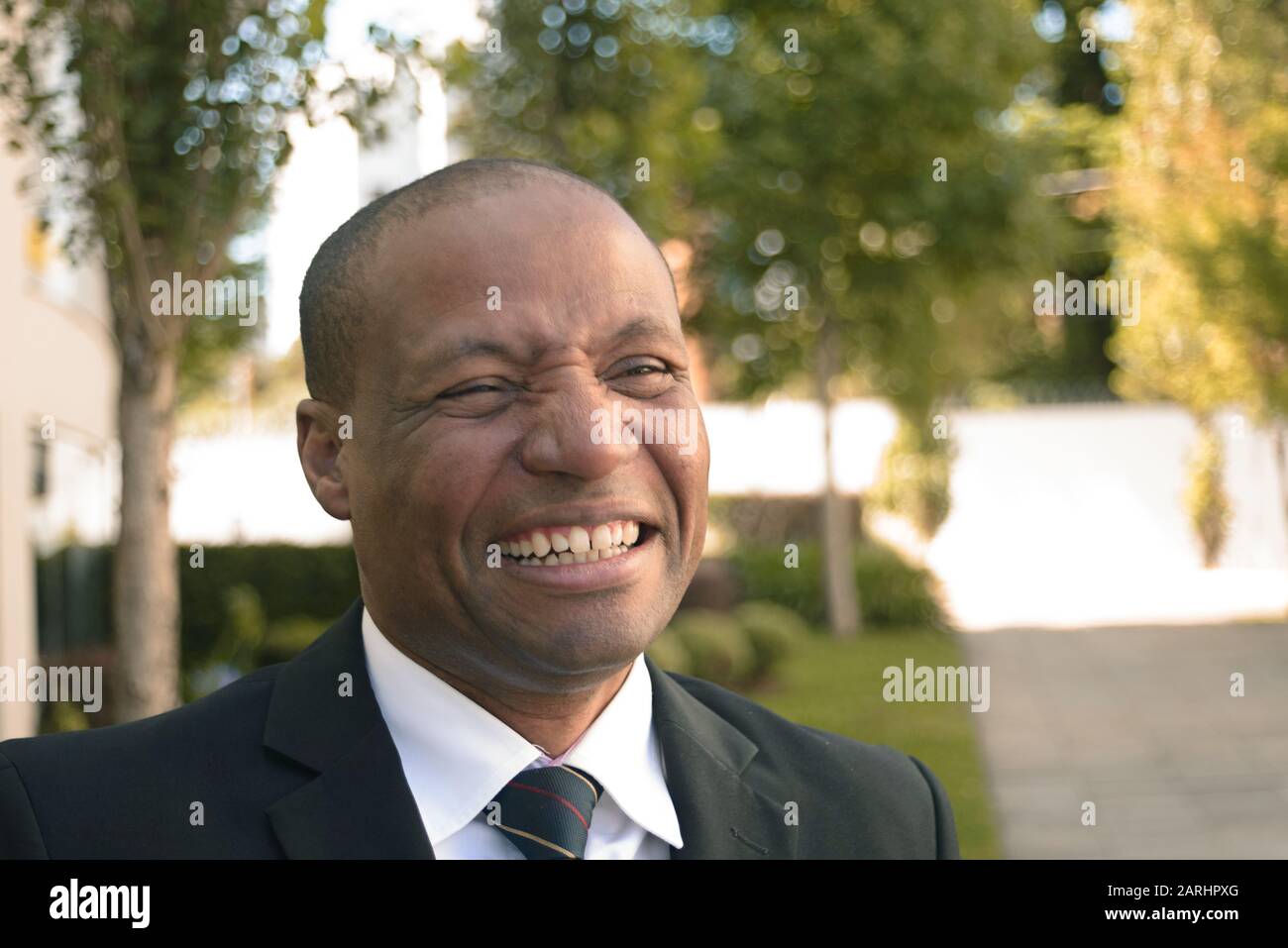 Homme d'affaires noir dans un costume regardant avec succès dans un milieu urbain Banque D'Images