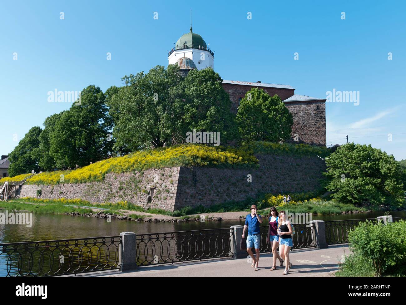 Vyborg, région de Leningrad, Russie - 8 juin 2019: Groupe de touristes marchant sur le remblai près du château médiéval de Vyborg sur l'île Banque D'Images