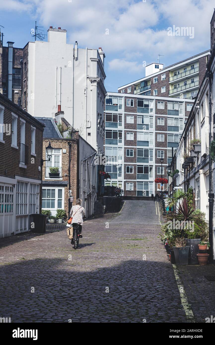 Londres/UK - 22/07/19: Une femme est en vélo dans un Mews à Bayswater, un quartier riche de la Cité de Westminster. C'est aussi l'un des mois de Londres Banque D'Images