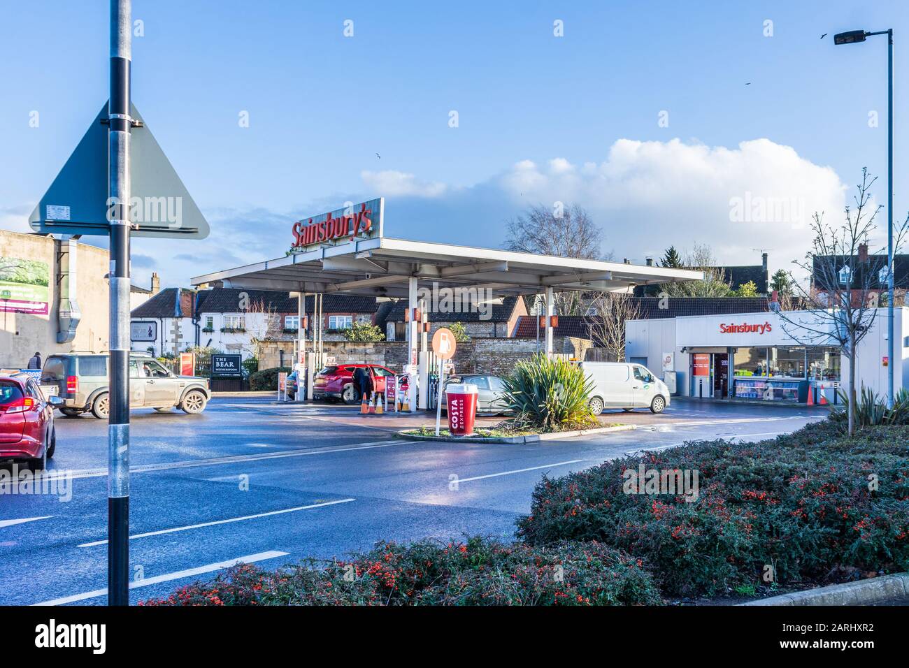 Station-service Sainsburys avec véhicules faisant la queue pendant un hiver ensoleillé en fin d'après-midi Banque D'Images