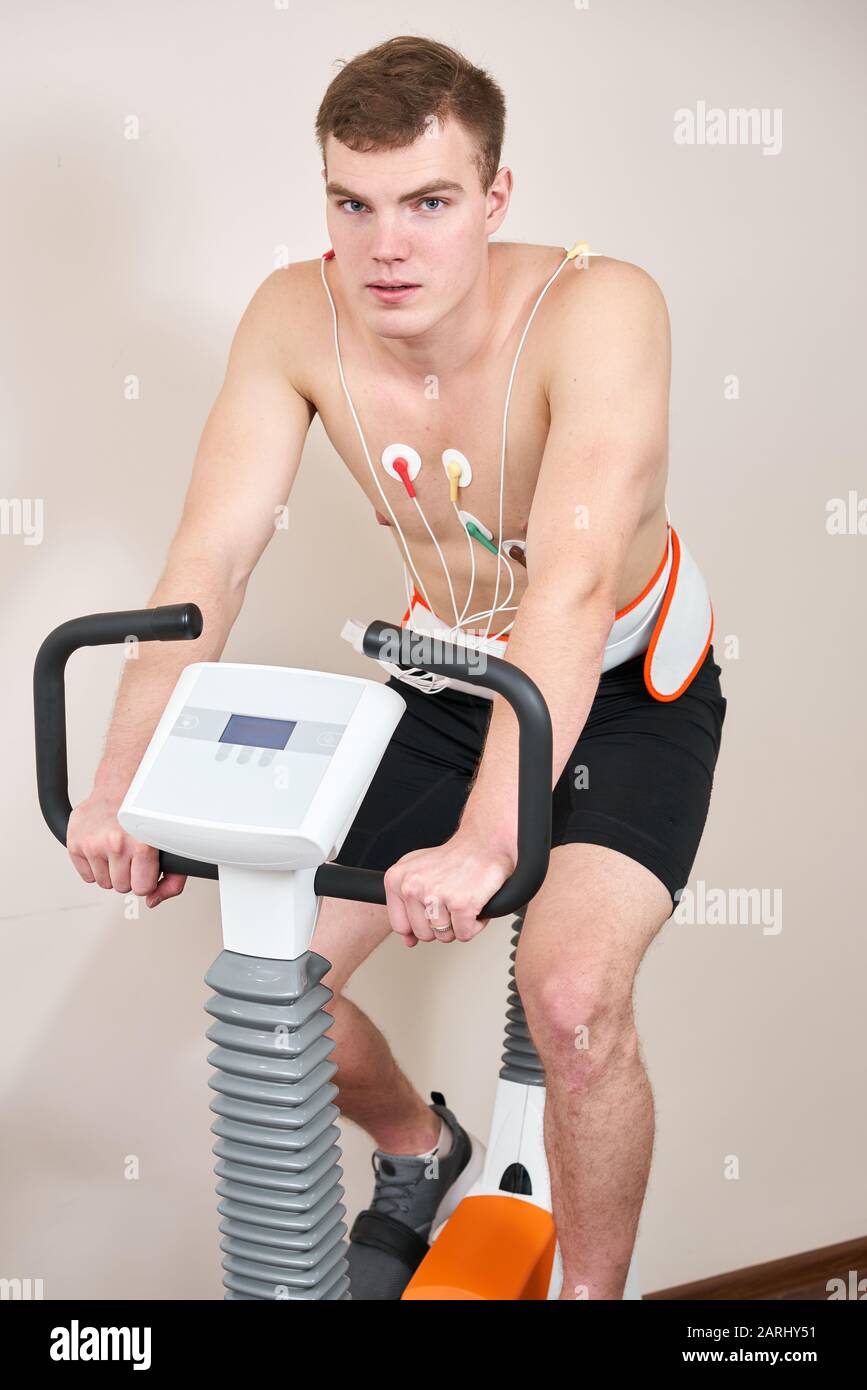 Homme patient, pédaler sur un système de test de stress ergomètre de vélo pour la fonction de coeur vérifiée. L'athlète effectue un test de stress cardiaque dans un médecin Banque D'Images