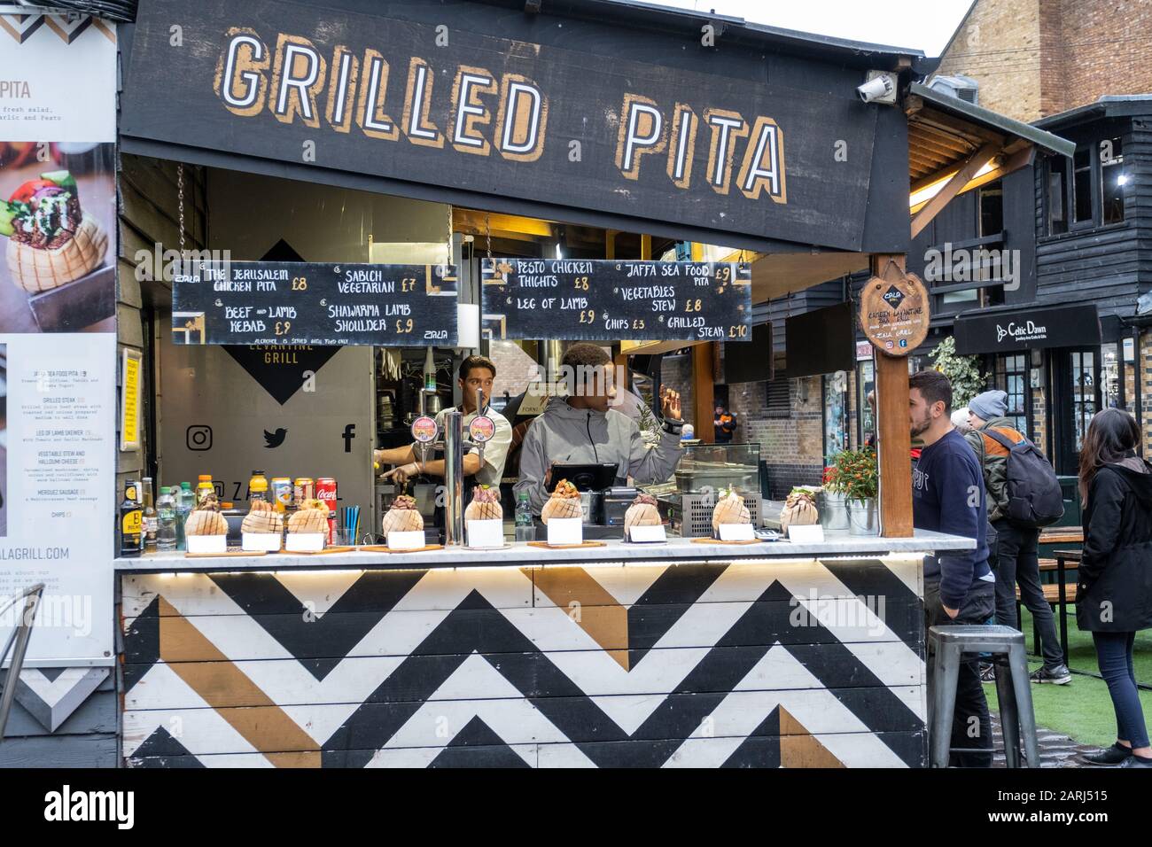 Londres / Royaume-Uni - 26 novembre 2019: Homme commandant de la nourriture dans le stand 'Grilled Pita' à Camden Market à Londres Banque D'Images