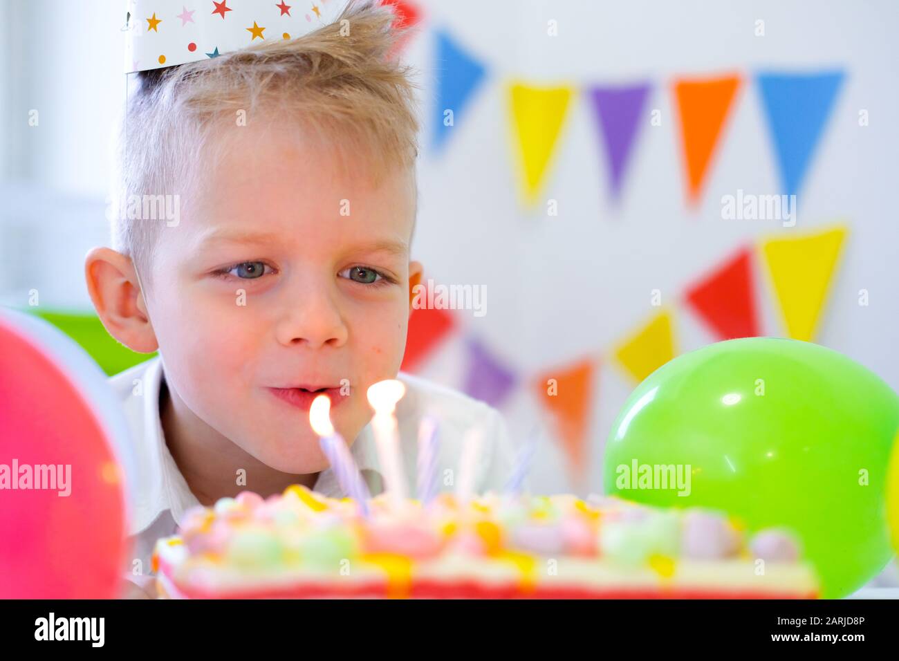 Anniversaire Garcon Regardant Des Bougies Sur Le Gateau Arc En Ciel Anniversaire Faisant Un Souhait Avant De Les Coups A La Fete D Anniversaire Arriere Plan Colore Avec Des Bulles Photo Stock Alamy