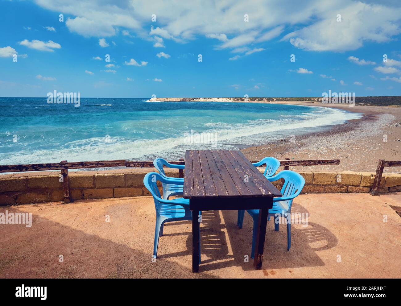 Des tables et des chaises dans un café avec des palmiers sur la plage Lara, Chypre Banque D'Images