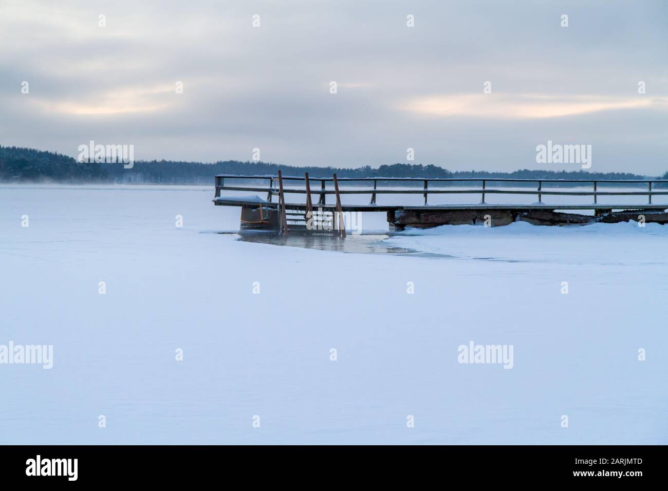 Magnifique paysage d'hiver avec jetée en bois recouverte de neige, Turku, Finlande. La natation d'hiver (ou la natation de trou de glace/piscine, quand fait dans un trou de glace) est un t Banque D'Images