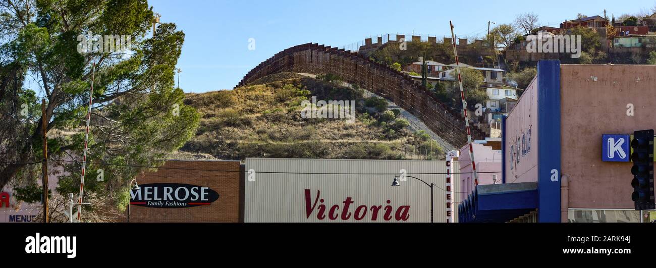 Vue panoramique sur la scène de la rue du quartier commerçant du centre-ville de Nogales, AZ, à la frontière avec MX, l'arrière-plan révèle la clôture de la frontière des lattes métalliques Banque D'Images